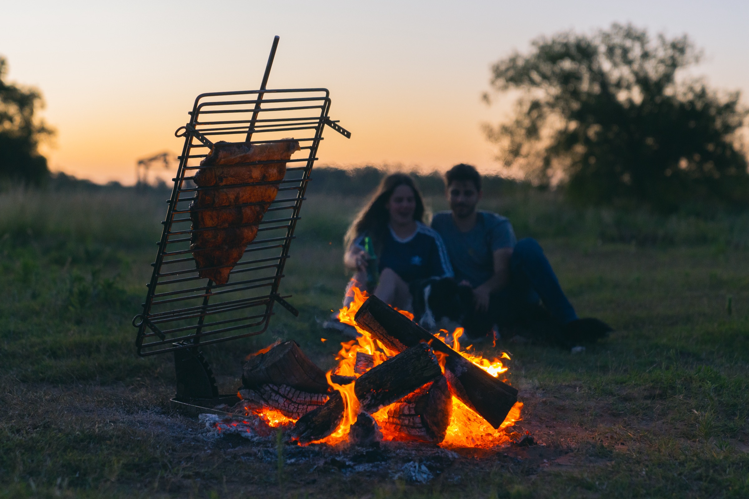 A La Cruz grill over open fire at sunset
