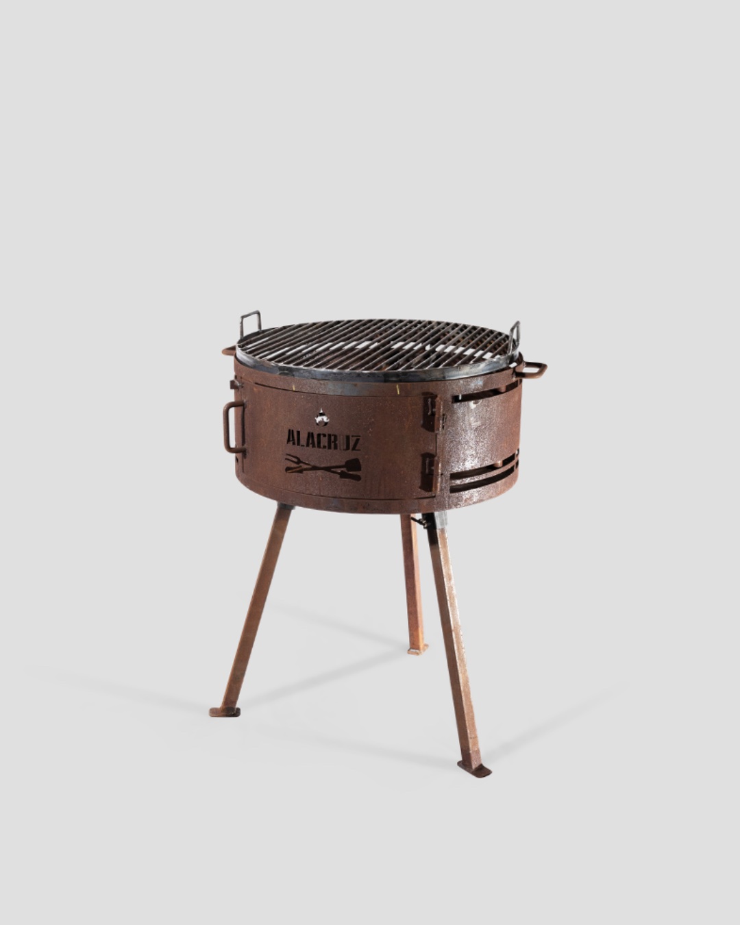 A skillet and steaks cooking over the coals on a Pampeano